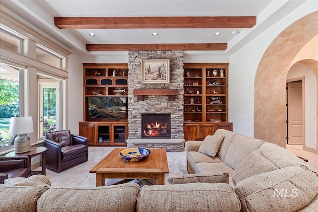215 W Riverbridge Ln, Eagle, ID 83616 - carpeted living room featuring beam ceiling, arched walkways, and a stone fireplace