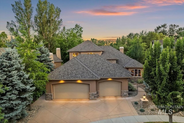215 W Riverbridge Ln, Eagle, ID 83616 - french country home with stone siding, stucco siding, concrete driveway, a garage, and a chimney
