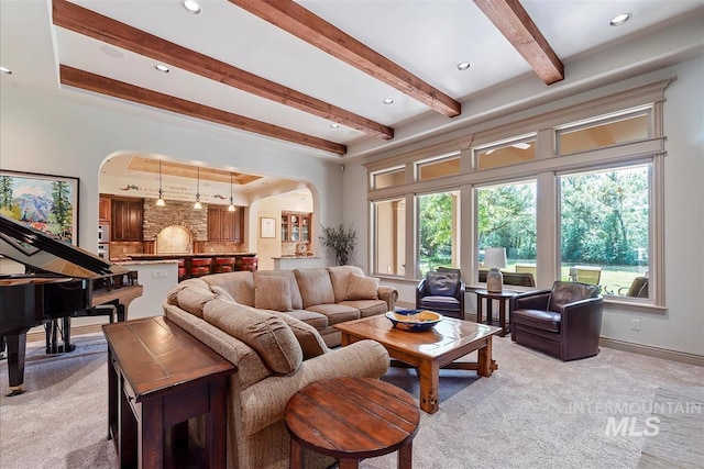 215 W Riverbridge Ln, Eagle, ID 83616 - living room featuring arched walkways, light colored carpet, and beamed ceiling