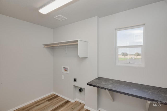 clothes washing area featuring visible vents, washer hookup, laundry area, light wood finished floors, and hookup for an electric dryer