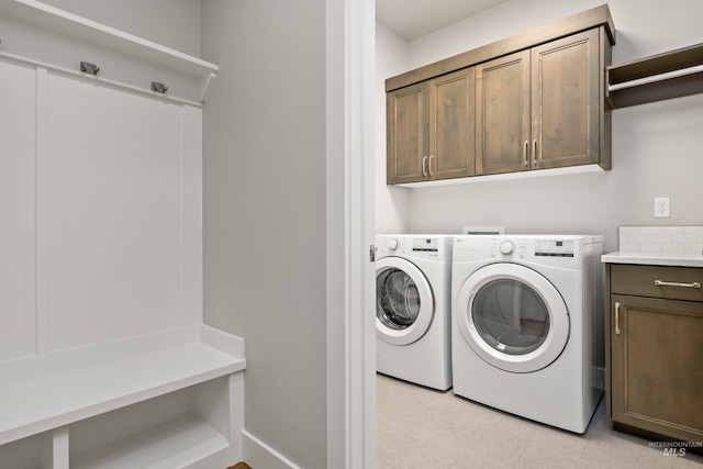 laundry area featuring separate washer and dryer and cabinets