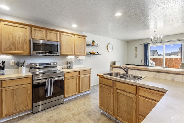 kitchen with stainless steel appliances, light countertops, a sink, and open shelves