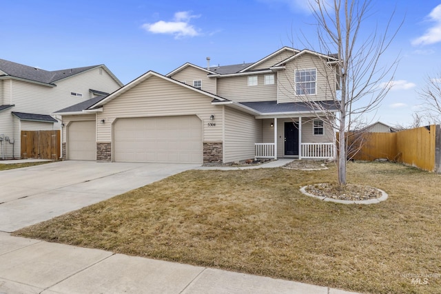 view of front of property with a porch, concrete driveway, fence, and a garage