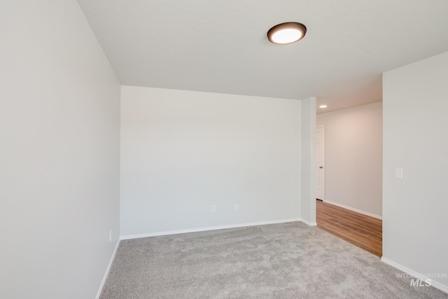 unfurnished room with light carpet, recessed lighting, and baseboards