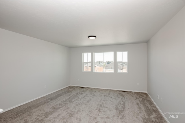 empty room with light carpet and baseboards