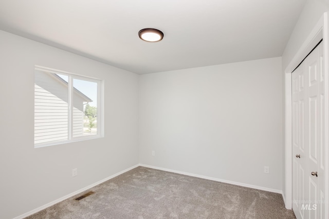 unfurnished bedroom with baseboards, a closet, visible vents, and light colored carpet