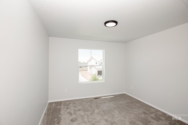 unfurnished room featuring baseboards and light colored carpet