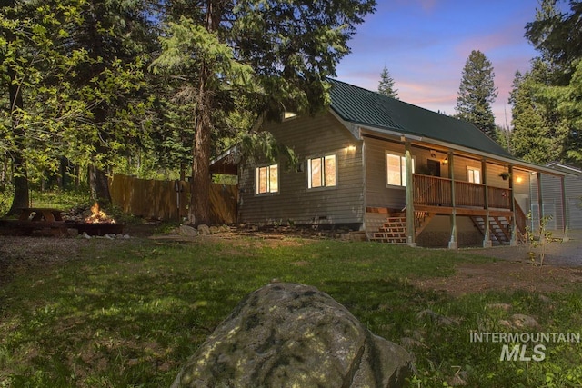 429 Doriann Dr, Cascade, ID 83611 - back of house at dusk featuring stairway, metal roof, a fire pit, and a standing seam roof