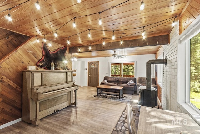 429 Doriann Dr, Cascade, ID 83611 - living room featuring a wood stove, wood finished floors, wooden ceiling, ceiling fan, and wood walls