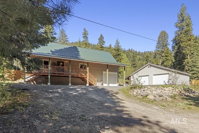 429 Doriann Dr, Cascade, ID 83611 - view of front of property with a porch, stairway, metal roof, a wooded view, and a detached garage