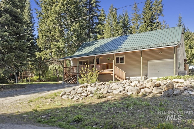 429 Doriann Dr, Cascade, ID 83611 - view of front of home featuring covered porch, metal roof, stairs, and an attached garage