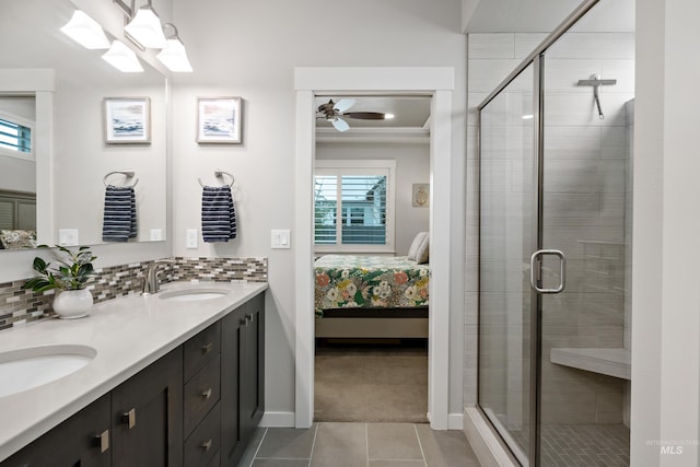 bathroom featuring tile patterned flooring, ceiling fan, a shower with door, and backsplash