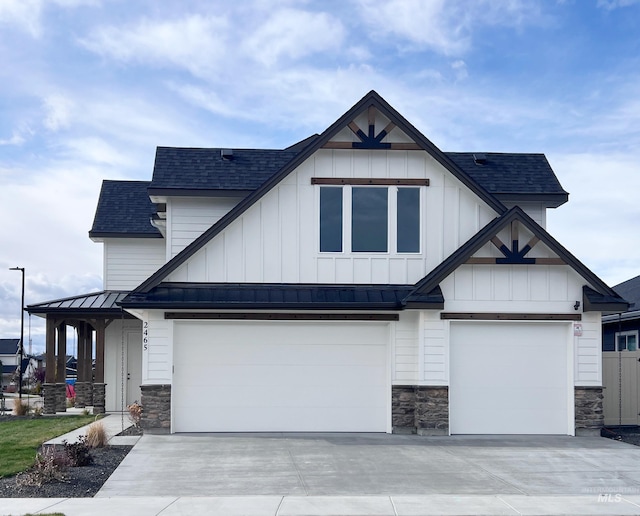 view of front facade with metal roof, driveway, stone siding, roof with shingles, and a standing seam roof