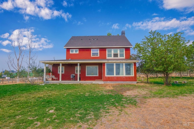 rear view of property featuring a yard