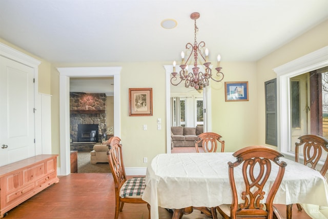 dining area featuring an inviting chandelier, dark hardwood / wood-style floors, and a fireplace