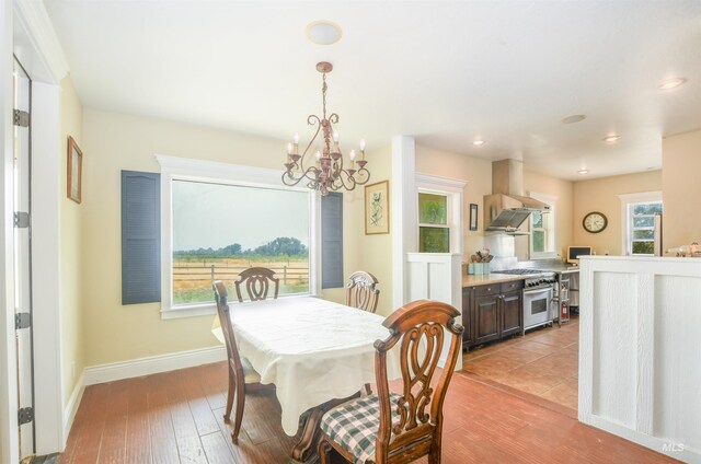 20169 Hoskins Rd, Caldwell, ID 83607 - dining space featuring light wood-type flooring, baseboards, a notable chandelier, and a healthy amount of sunlight