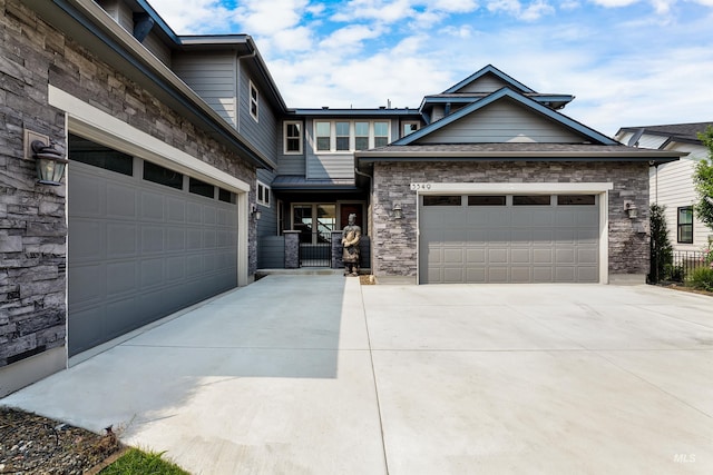 view of front of home featuring a garage, stone siding, and driveway