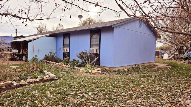 view of side of home with an outbuilding, a yard, and cooling unit