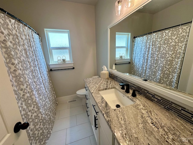 bathroom featuring toilet, decorative backsplash, vanity, and tile patterned floors