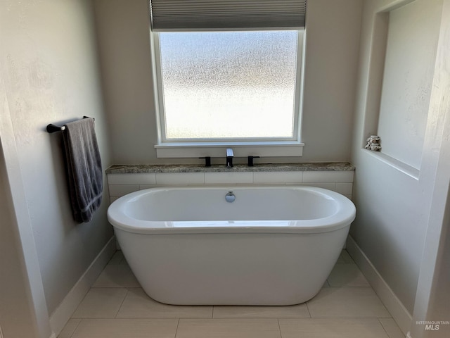 bathroom featuring a washtub and tile patterned flooring