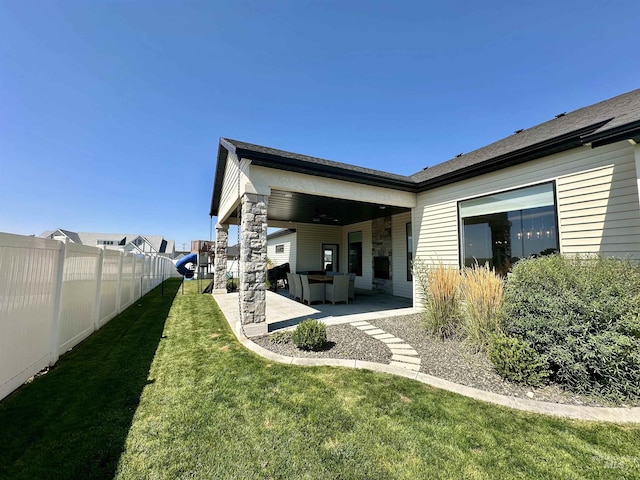 back of property featuring a lawn and a patio area