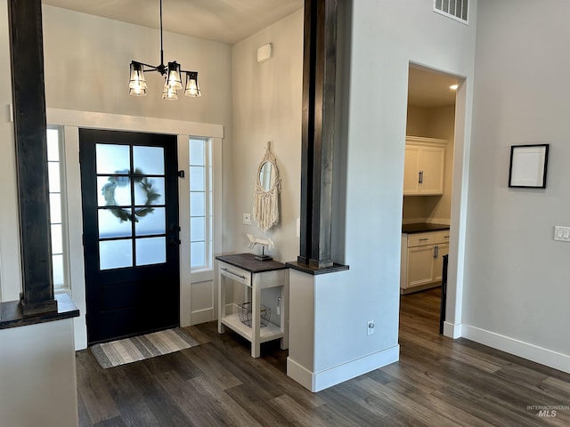 entryway with dark hardwood / wood-style flooring and an inviting chandelier