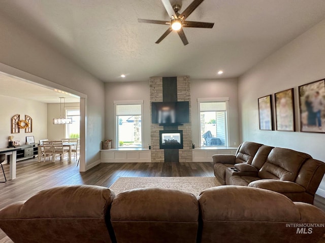 living room with a fireplace, hardwood / wood-style floors, a textured ceiling, and ceiling fan