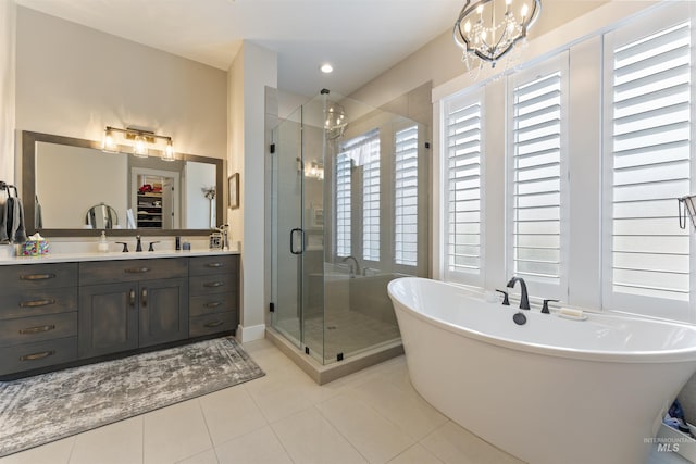 full bathroom with a walk in closet, a shower stall, vanity, tile patterned flooring, and a freestanding tub