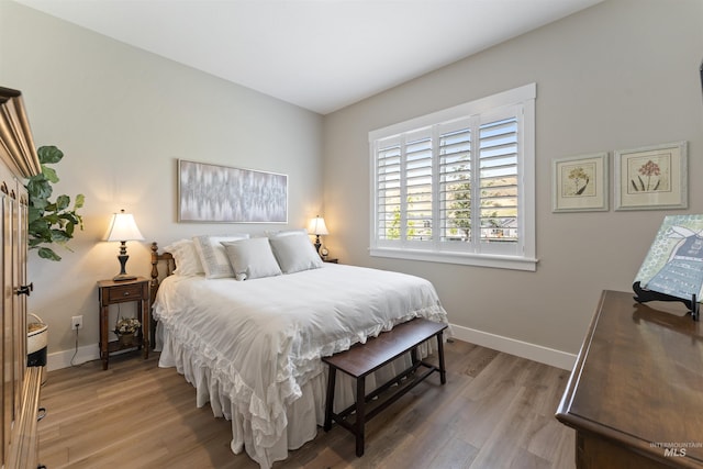 bedroom with baseboards and wood finished floors