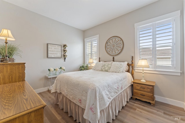 bedroom featuring light wood-style floors and baseboards