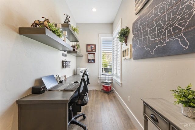 home office with light wood-type flooring and baseboards