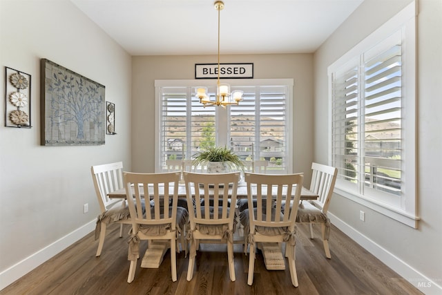 dining area with a chandelier, dark wood-type flooring, and baseboards