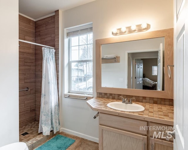 full bath featuring vanity, ensuite bath, baseboards, and a shower stall