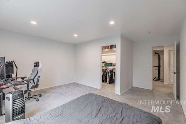 bedroom with a spacious closet, carpet, baseboards, and recessed lighting