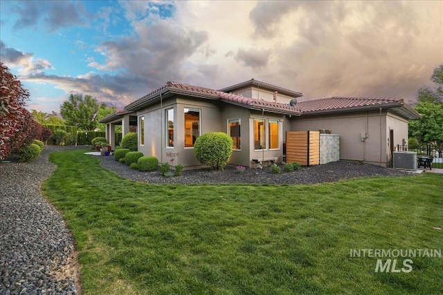1480 N Colline Bello, Eagle, ID 83616 - rear view of house featuring central AC, a tiled roof, and a lawn