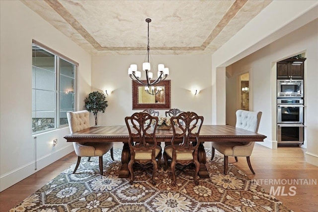 1480 N Colline Bello, Eagle, ID 83616 - dining room with wood finished floors, a chandelier, and baseboards