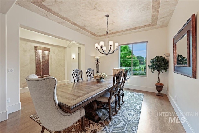 1480 N Colline Bello, Eagle, ID 83616 - dining area featuring wood finished floors, a tray ceiling, a chandelier, and baseboards