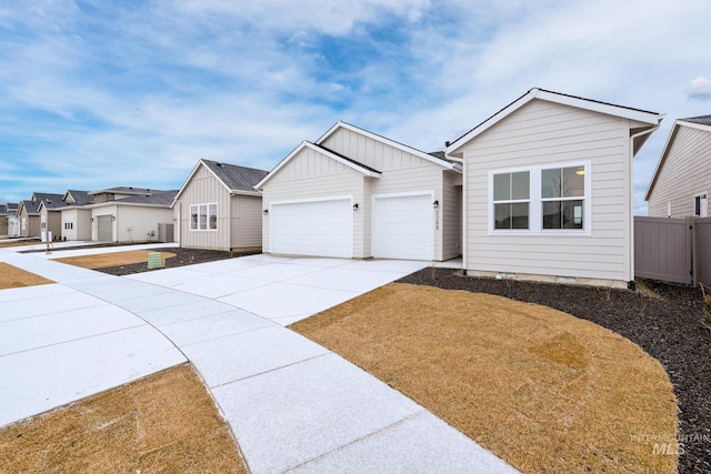 view of front of property with driveway, a garage, crawl space, fence, and board and batten siding