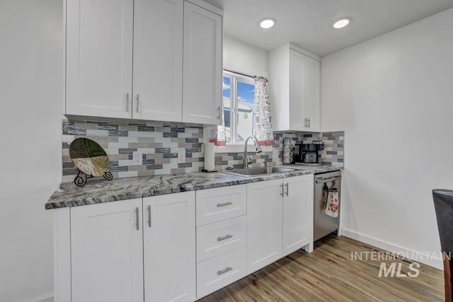 1930 Poplar Ave, Twin Falls, ID 83301 - kitchen with stainless steel dishwasher, backsplash, white cabinetry, light stone countertops, and light wood-type flooring