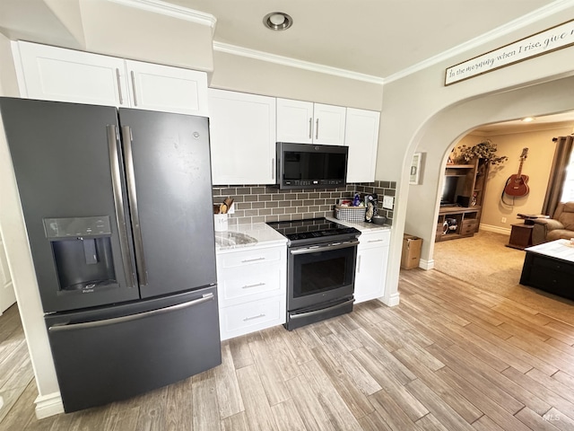 1128 30th St, Lewiston, ID 83501 - kitchen with stainless steel fridge, range with electric stovetop, ornamental molding, arched walkways, and white cabinetry