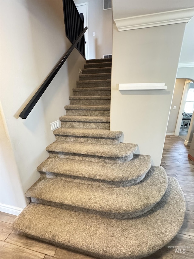 1128 30th St, Lewiston, ID 83501 - staircase with arched walkways, wood finished floors, crown molding, and baseboards
