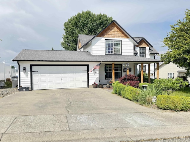 1128 30th St, Lewiston, ID 83501 - view of front of home with an attached garage, driveway, a porch, and a shingled roof