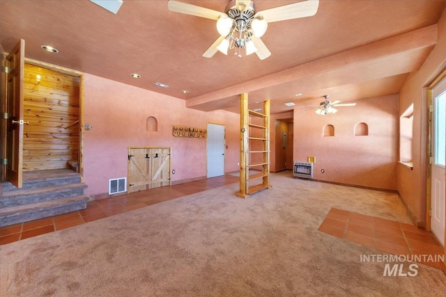 empty room featuring carpet, heating unit, and ceiling fan