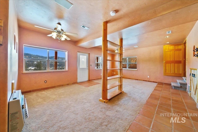 carpeted living room with heating unit and ceiling fan