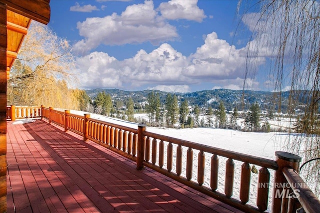 snow covered deck with a mountain view