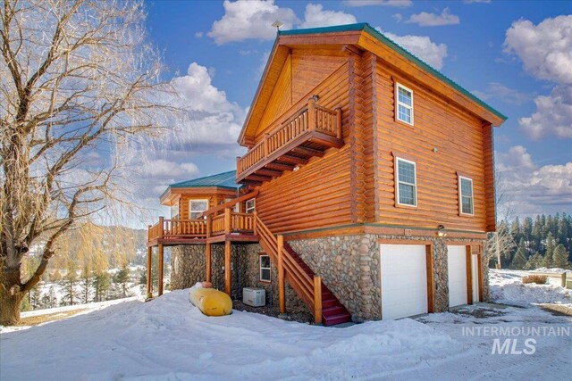 view of snow covered exterior featuring a garage and a balcony