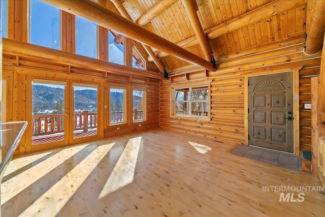 unfurnished sunroom with a mountain view, lofted ceiling with beams, and wood ceiling