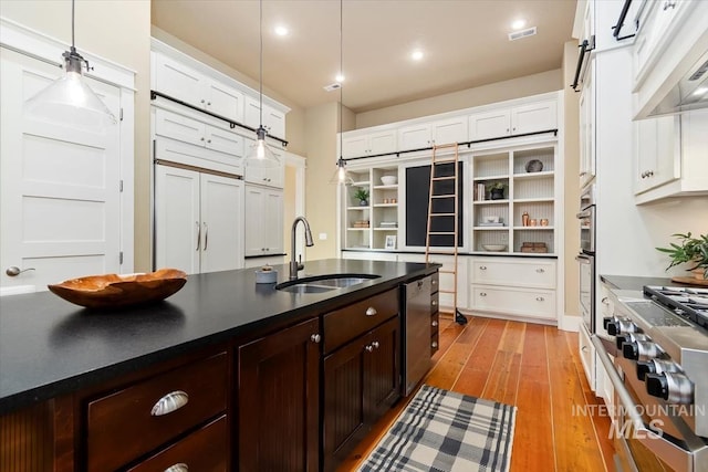 kitchen with sink, decorative light fixtures, stainless steel appliances, range hood, and white cabinets