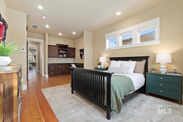 bedroom with multiple windows and light hardwood / wood-style floors