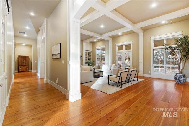 corridor with beamed ceiling, coffered ceiling, and light hardwood / wood-style flooring